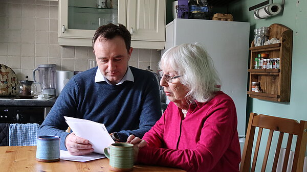 Dann with pensioner looking at bill