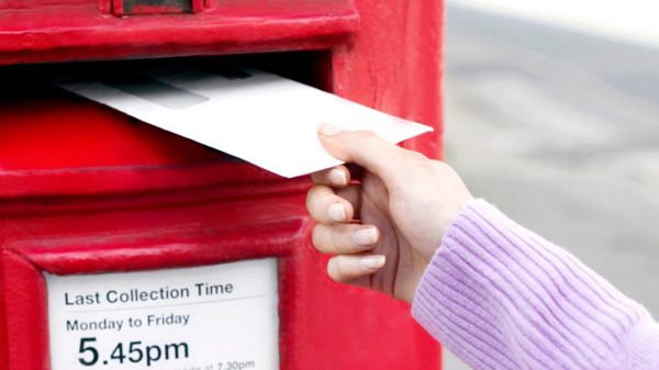 Person posting an envelope into a postbox