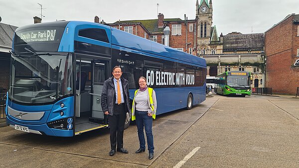 Kelsie Learney and Martin Tod in front of an electric bus