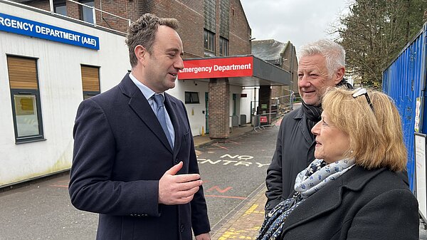 Danny talking to group of people outside of Winchester's hospital