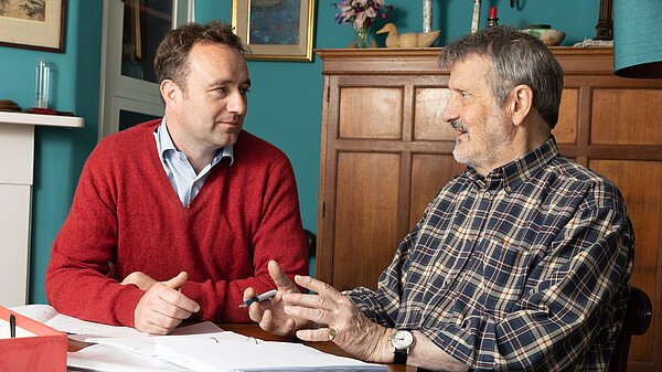 Danny talking to man in kitchen table