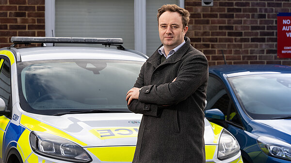 Danny in front of police car