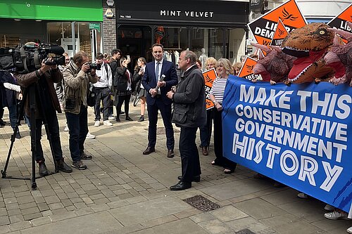 Ed Davey speaking in Winchester next to a banner saying 'Make This Conservative Government History'