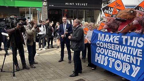 Ed Davey speaking in Winchester next to a banner saying 'Make This Conservative Government History'